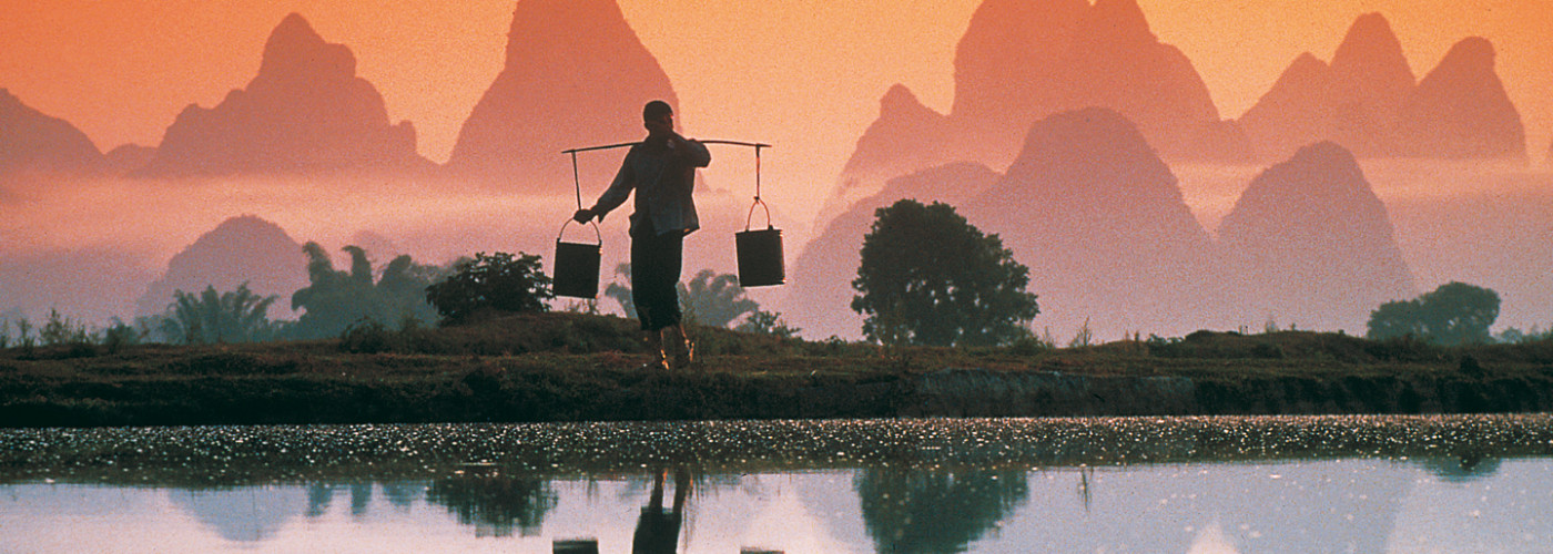 Porteur d'eau sur une rizière, Xingping, Chine
